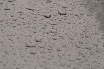 Background - raindrops on the metal surface of a modern car