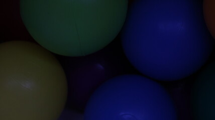 Red, yellow, green and blue toy balls close-up, playful texture background
