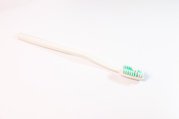 A clean, minimalist shot of toothpaste on a toothbrush, set against a bright white background, conveying a sense of freshness and oral hygiene.