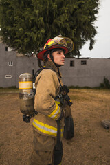 Brave firefighter putting on his air tank gear and other equipment to go fight a fire.