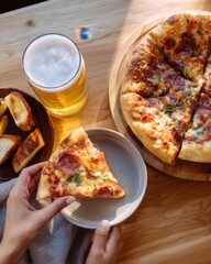 Overhead shot of beer and pizza slice being lifted, casual dinner scene, warm tones