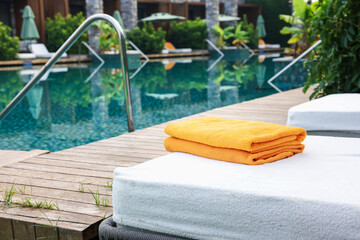 Sun loungers near outdoor swimming pool at luxury resort