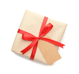 Gift wrapped in kraft paper with bow and card isolated on white, top view