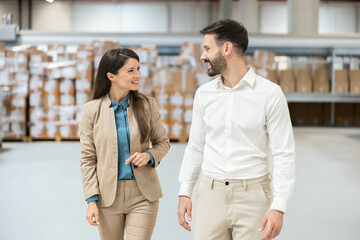 A professional couple collaborates in a modern warehouse, discussing business strategies and fostering teamwork and innovation.