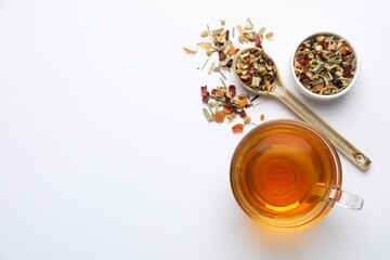 Delicious herbal tea and dry leaves on white background, top view. Space for text