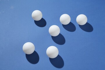 Many ping pong balls on blue background