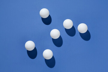 Many ping pong balls on blue background, flat lay