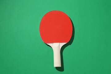 One ping pong racket on green background, top view