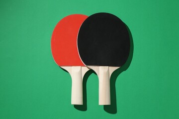Ping pong rackets on green background, top view