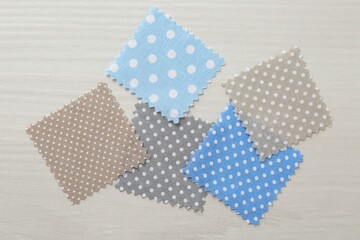 Samples of different fabrics on white wooden table, flat lay