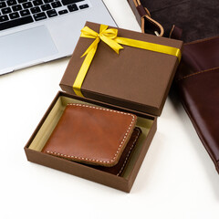 Brown leather wallet with gift box between gadgets. Perfect for leather product catalog design