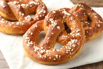 Tasty pretzels with salt on table, closeup