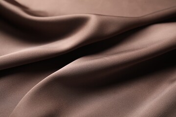 Crumpled light brown silk fabric as background, closeup