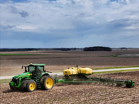 Rockford, Illinois - April 23, 2025: John Deere 410 8R tractor pulling a John Deere 1775NT 24 row planter.