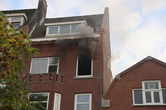 house on fire smoke coming out of a window