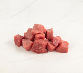 Pile of fresh raw beef cubes ready for cooking on white surface – High Resolution Raw Meat Image for Food Industry or Food Packaging