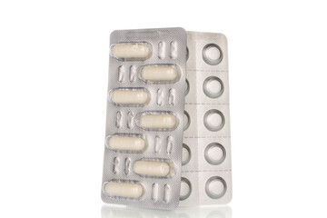 Medical pills in blister packaging, close-up, isolated on white background.