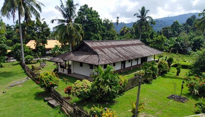 Fototapeta premium Traditional Masai Enkaji House Surrounded by Lush Greenery