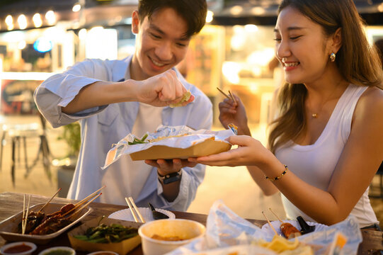 Close-up of two friends squeezing lime over Pad Thai at a street food market, A Shared Street Food Moment Concept