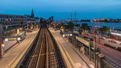 Aerial day to night timelapse of trains arriving at Landungsbrucken station in Hamburg, Germany.