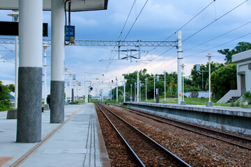 Taiwan May 21, 2024: A railway track curving into the distance beside a station platform,...