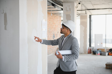 Arab Architect inspecting construction site and pointing at wall