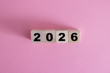 2026 on natural wooden cube highlighted by the sun, Concept to welcome the New Year 2026