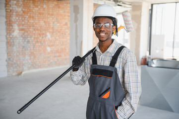 Construction worker holding paint roller on building site