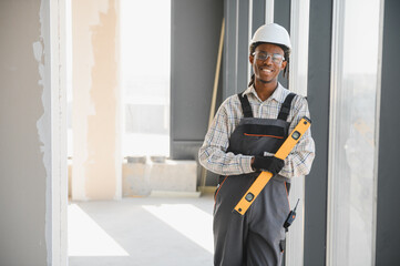 Construction worker holding spirit level in building under construction