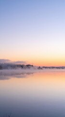 Fototapeta premium Serene Sunrise Over Calm Lake with Soft Pastel Colors and Mist