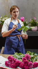 A florist makes a bouquet of pink roses in a flower shop. Small business.  Close-Up.