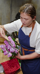 A florist unpacks a package of roses lying on a table in a flower shop. Small business.  Close-Up.  Soft focus