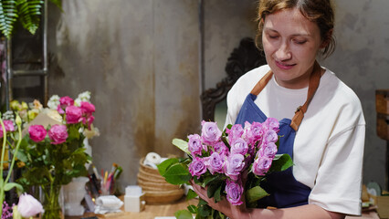 A florist unpacks a package of roses lying on a table in a flower shop. Small business.  Close-Up.  Soft focus