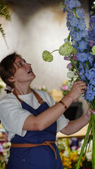 A florist in a flower shop makes a bouquet of blue delphiniums. Small business.  Close-Up.  Soft focus.