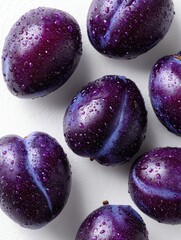 Fresh, vibrant plums with water droplets