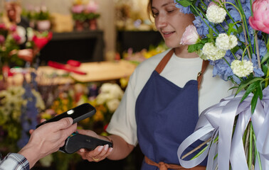A florist makes a bouquet of pink roses in a flower shop. Small business.  Close-Up.