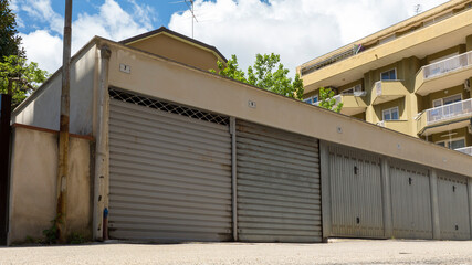 Low angle view of a street with many closed garages.