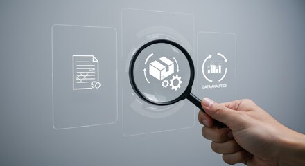 Hand holds magnifying glass focusing on delivery box, file, and analytics icons