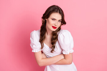 Graceful young woman with charming smile wearing elegant white dress posing in front of a vibrant...