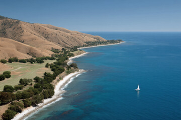Fototapeta premium aerial view of dramatic coastal cliffs meeting ocean with solitary yacht on horizon