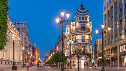 Obraz premium Illuminated Adriatica building on Avenida de la Constitucion at night, Seville, Spain