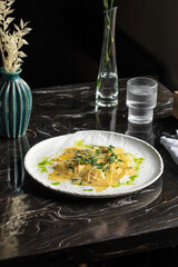 Portion of italian ravioli dumplings dish with sauce and green oil