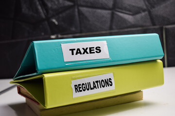 folders with labels taxes and regulatoins, financial compiance and legal obligations concept