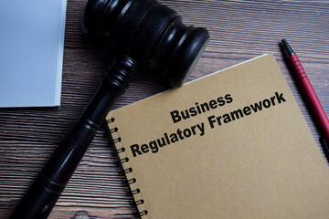 Concept of Business regulatory framework write on book isolated on Wooden Table.