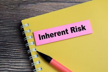 Concept of Inherent Risk write on sticky notes isolated on Wooden Table.
