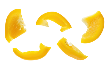 Isolated yellow bell pepper slices arranged on a black background in a studio setting for food photography