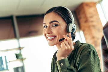 Confident businesswoman with headset working in a modern office environment with a cheerful and professional demeanor