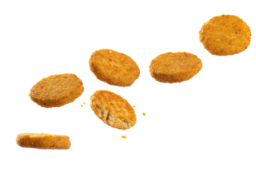 A view of six golden brown hash browns arranged on a plain black background in a studio setting