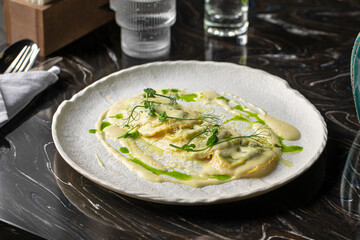 Portion of italian ravioli dumplings dish with creamy sauce