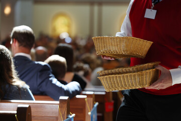 Collection baskets are collected at a Catholic service. 